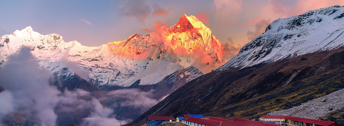 Annapurna Base Camp Trek, Nepal. Stunning view of snow capped mountains at sunrise with clouds 